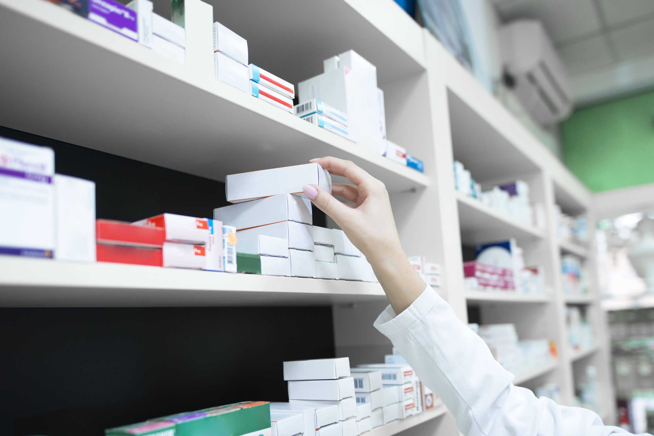 Immagine: closeup-view-of-pharmacist-hand-taking-medicine-box-from-the-shelf-in-drug-store